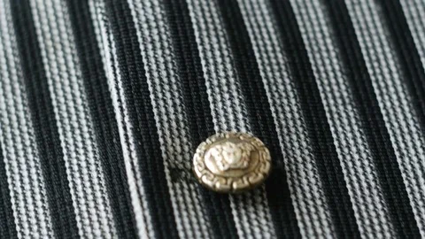 Silver button on dark stripe cotton fabric, 4k close up pan shot Video stock 77506938