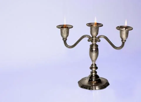 Silver candlestick holding three almost burnt-out candles Stock Photos