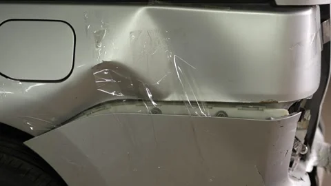 Silver car with damaged rear bumper temporary fixed with transparent tape. Stock Footage 343889207