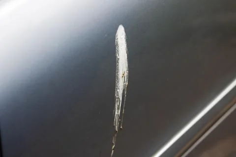 A silver car that has a noticeable scratch on its door area Stock Photos