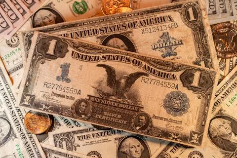 Silver certificate one Dollar banknote on top of Dollar coins and new USD Stock Photos