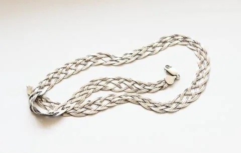 Silver chain located on a white background Stock Photos