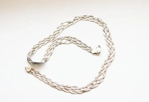 Silver chain located on a white background Stock Photos