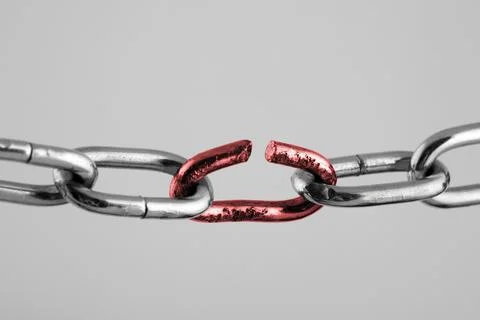Silver chain with red broken link, concept of freedom. Stock Photos