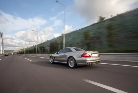 Silver chasing car on the mountain road, view from behind Stock Photos