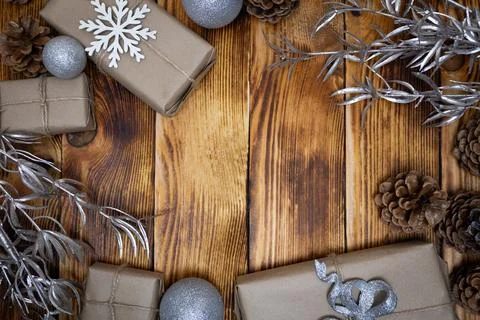 Silver Christmas elements crafted presents and pine cones on a wood back Stock Photos