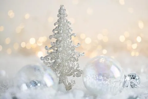 Silver Christmas tree surrounded by clear glass ornaments and snow with war.. Stock Photos