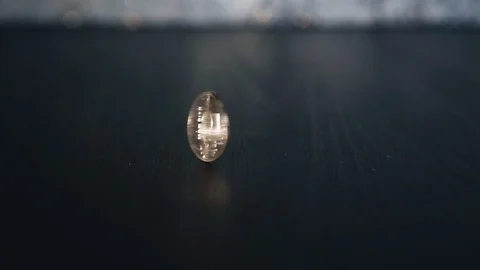 The silver coin quickly rotates standing on the edge. Close up. Beautiful light Stock Footage 110421369