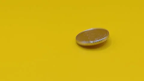 Silver coin on a yellow background Stock Footage 333925852