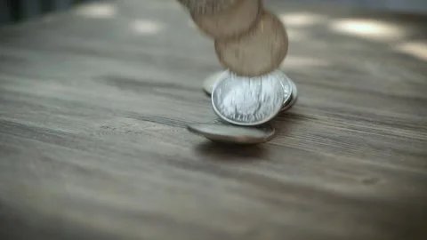 Silver coins falling in slow motion on a table. Slowmo American Dollars Falling Stock Footage 136811958
