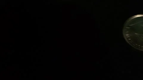 Silver coins roll across the screen, some come to rest in view Stock Footage 245370055