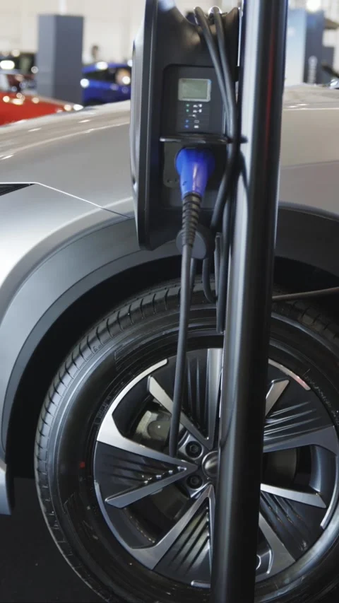 Silver colored electro car on charge at the charging station indoors Stock Footage 328452408
