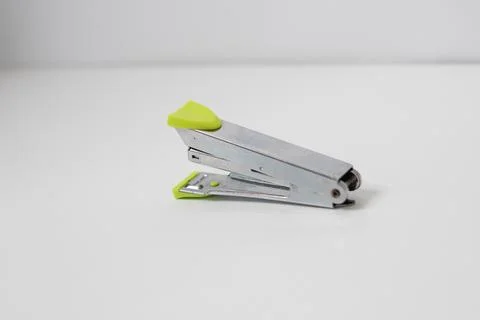 Silver colored stapler with green handle made of stainless steel Foto stock