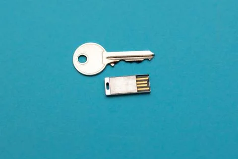 Silver colored USB-stick and key, isolated on blue close up Stock Photos