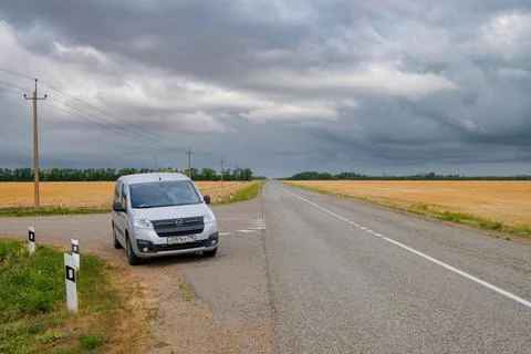 Silver compact minivan Opel Combo Life on a country road. Stock Photos