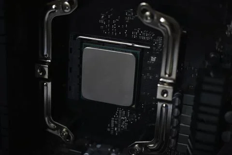 Silver computer processor on a black motherboard Stock Photos