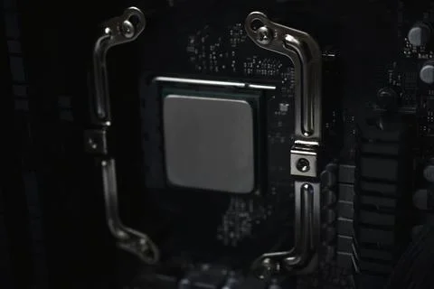 Silver computer processor on a black motherboard Stock Photos