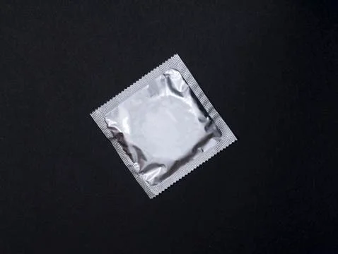  Silver Condom in package on black background. Stock Photos