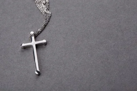 Silver cross on a gray background Stock Photos