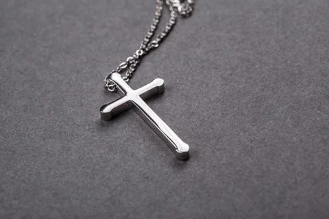 Silver cross on a gray background Stock Photos