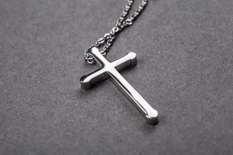 Silver cross on a gray background Stock Photos