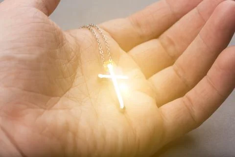 Silver cross in a hand Stock Photos