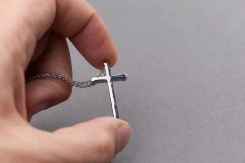 Silver cross in a hand Stock Photos