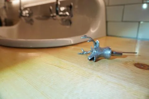 Silver Deer Head Bottle Stopper on Wooden Countertop - Lifestyle Still Life. Stock Photos