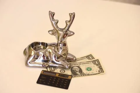 Silver deer symbol of financial success, dollar bills and calculator, backgro Stock Photos