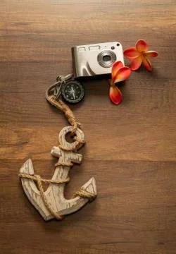 Silver Digital Camera with compass and anchor on wooden table Stock Photos