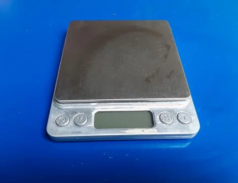 Silver digital scale in grams on a blue background. Stock Photos