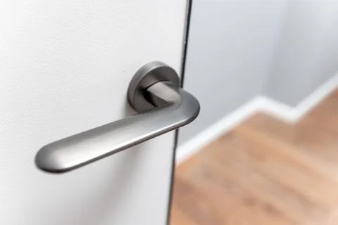 A silver door handle is shown in a mirror Stock Photos