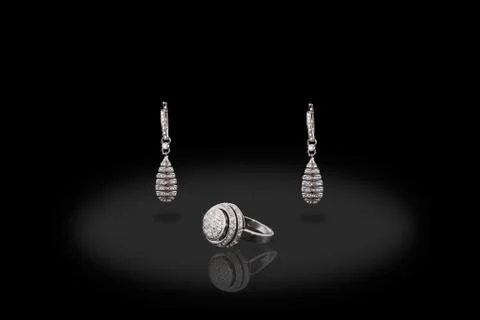 Silver drop precious ring earrings with diamonds on black background. Good ma Stock Photos