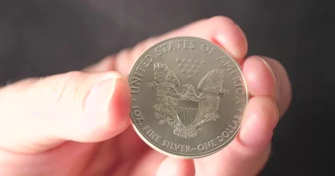 Silver eagle with smoke swirling being held by man isolated on black Video stock 207650546