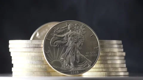 Silver eagles coin being shown isolated on black with smoke in slow motion Stock Footage 207649893