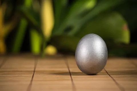 Silver easter eggs with craquelures in wicker basket. Stock Photos