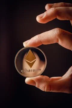 Silver Ethereum cryptocurrency in a hand Stock Photos