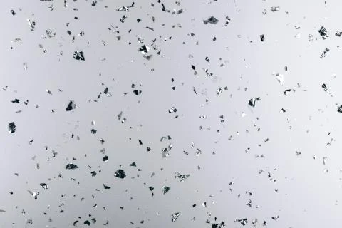 Silver falling confetti on metallic backdrop Stock Photos