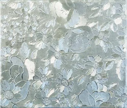 Silver flower embossing. Foil with pattern of flowers Stock Photos