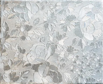 Silver flower embossing. Foil with pattern of flowers Stock Photos