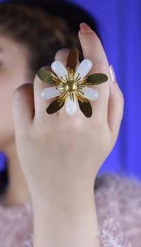 Silver flower-shaped ring on model’s hand, macro close-up jewelry shot Stock Photos