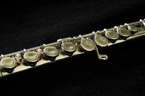 Silver flute close-up on black background, short depth of field. Stock Photos