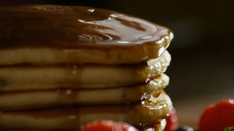 Silver fork cutting into a stack of maple drizzled pancakes, in slow motion  Stock Footage 65282008