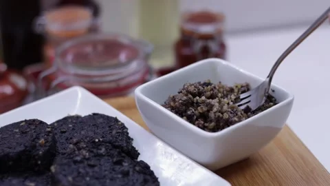 Silver fork lifting up cooked haggis food from white bowl Stock Footage 328716147