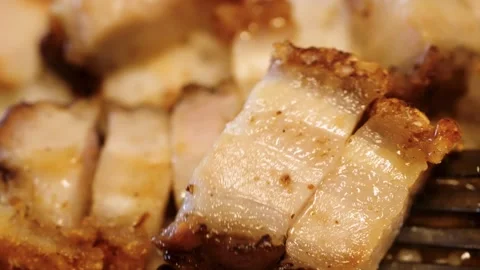 A silver fork is shown poking into a savory Chinese crispy pork dish atop a bed Video stock 240554077