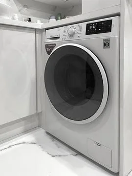 Silver front-loading washing machine with a digital display and control knob Stock Photos
