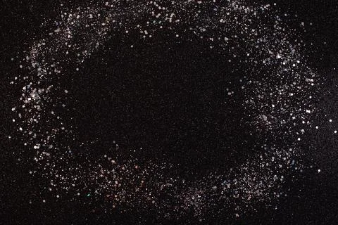 Silver glitter texture on a black background. Stock Photos