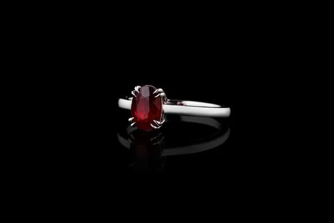 Silver, gold ring with garnet stone and diamonds on black background 스톡 사진
