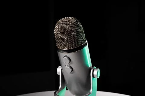Silver grey USB condenser microphone with adjustable tabletop stand sitting o Stock Photos