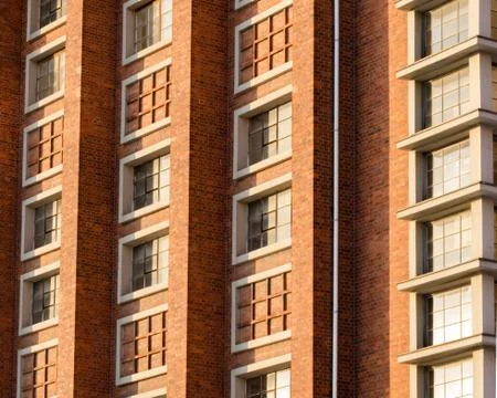 A silver gutter is attached to the red brick facade Stock Photos